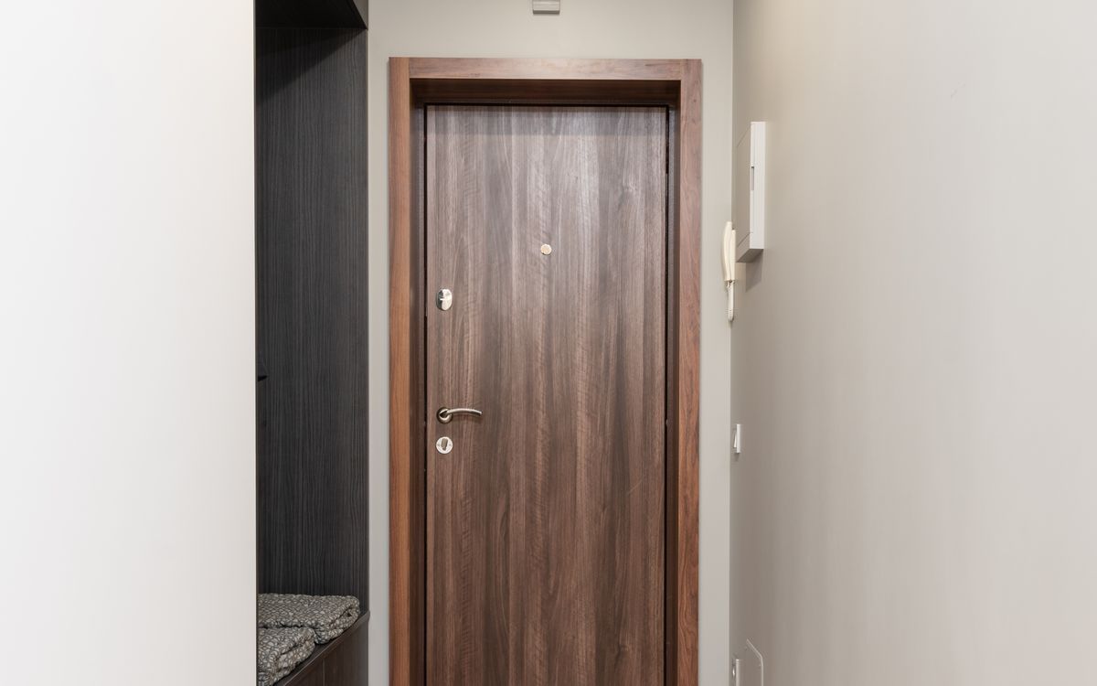 An empty apartment entryway with a closed wooden front door