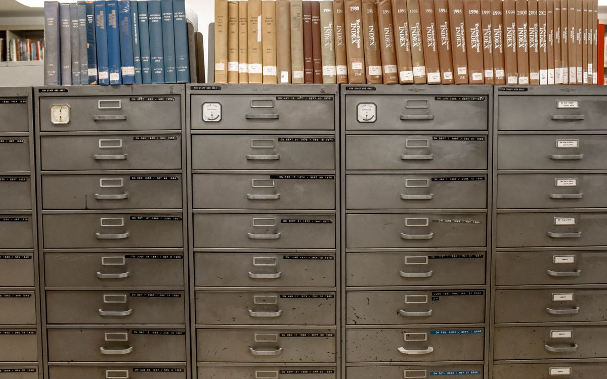 A wall of gray metal filing cabinets with year labels on the drawers