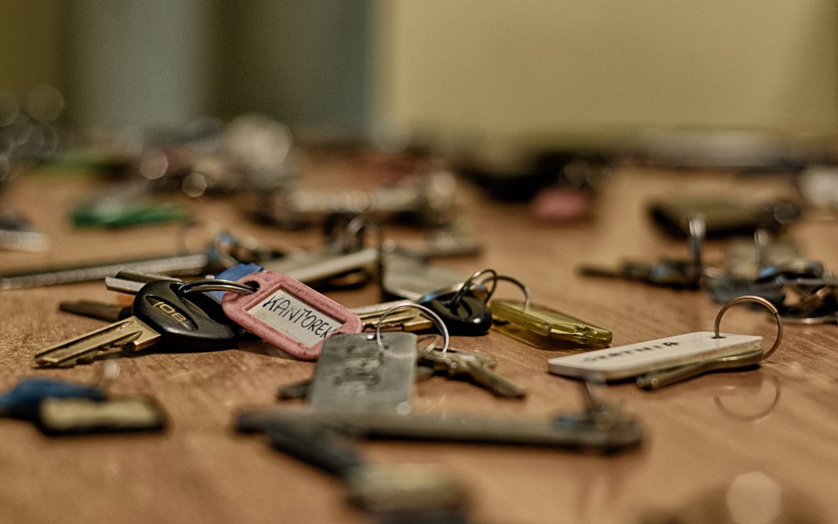 Several sets of labeled keys scattered across a wooden table