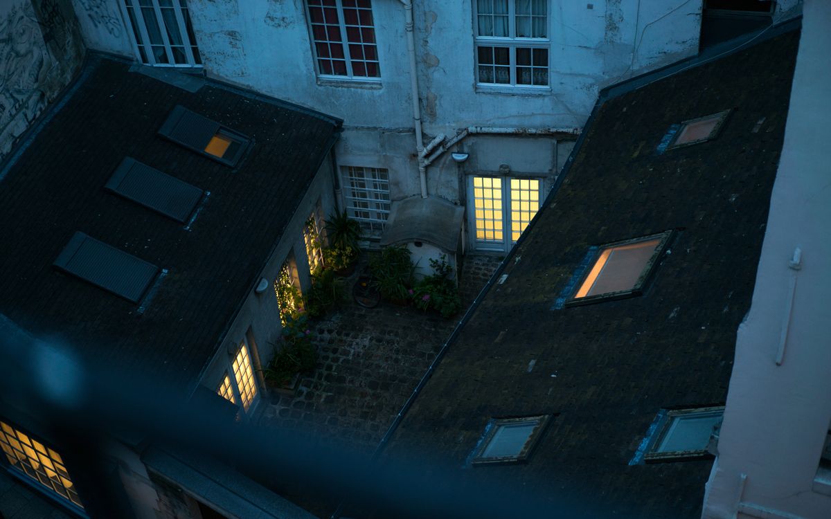 Lit windows around a courtyard at twilight, seen from above