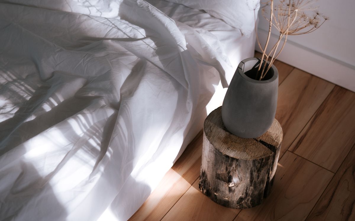 Morning light falling across white bedding and a wooden floor