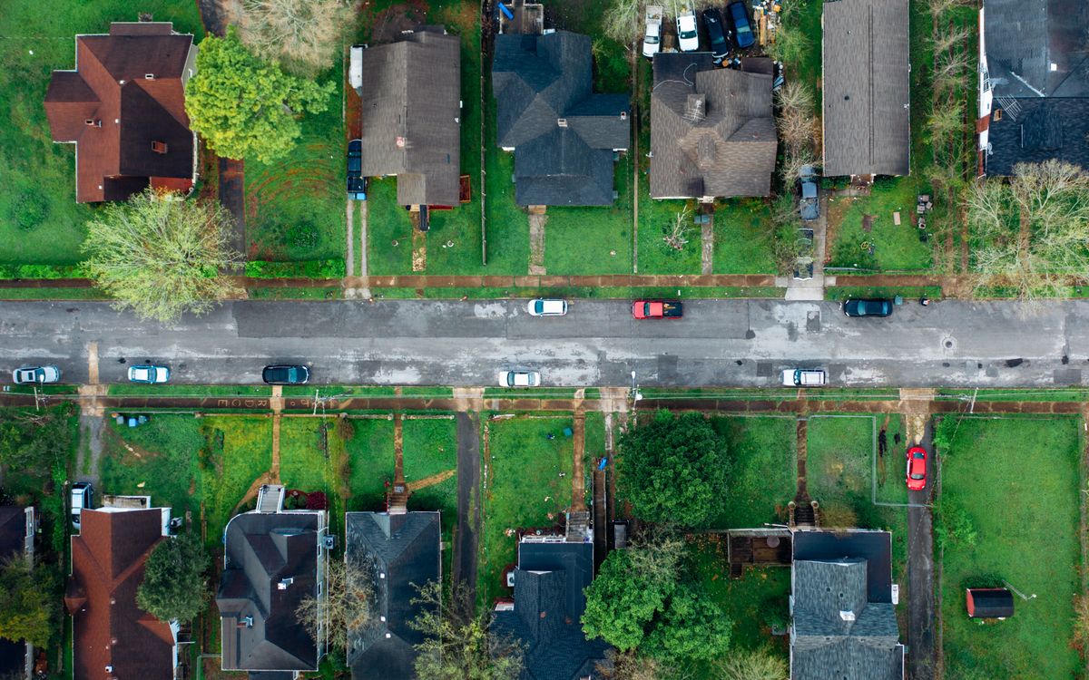 An overhead view of a residential street, houses and yards on both sides