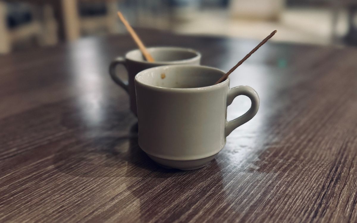 Two empty coffee cups left on a wooden table
